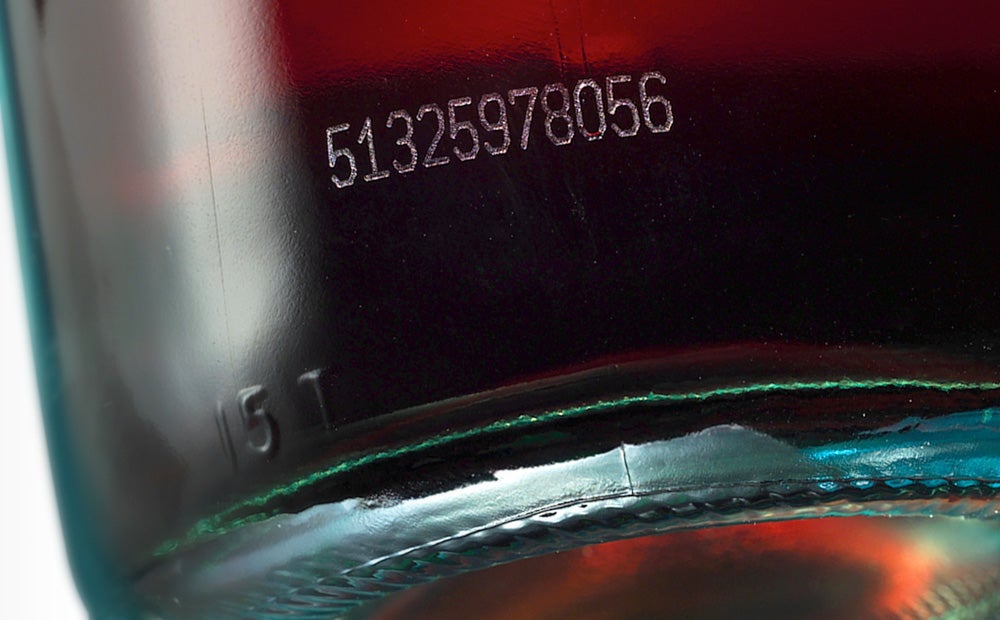 Laser marked serial number on glass beverage bottle for product traceability
