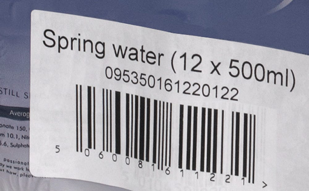 Videojet 9560 print and apply labeler applying wrap around label on plastic film beverage packaging.