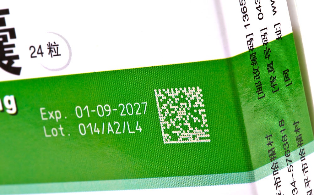 Videojet 3640 laser marking machine applying 2D codes and lot numbers on pharmaceutical carton boxes for traceability.